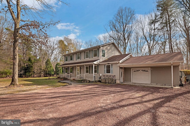 view of front of house with a front yard, an attached garage, and dirt driveway