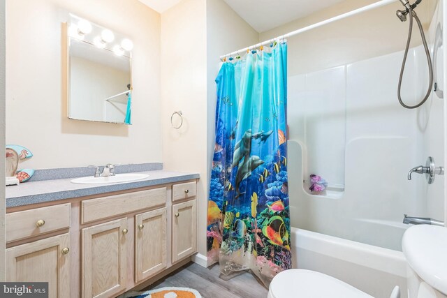 full bathroom featuring vanity, toilet, wood finished floors, and shower / bath combo with shower curtain