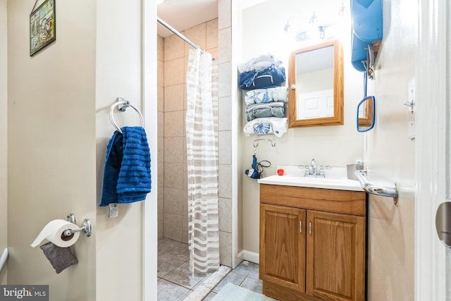 bathroom featuring vanity, tile patterned floors, and tiled shower