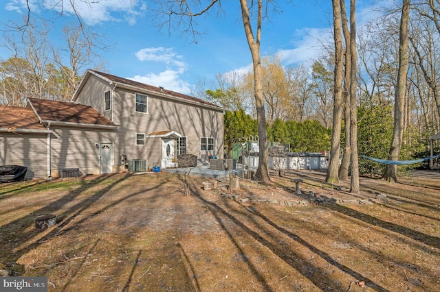 rear view of property with central air condition unit and a patio