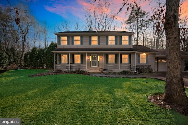 colonial-style house with a front lawn, a carport, and covered porch