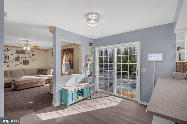 living room with baseboards, a ceiling fan, and wood finished floors