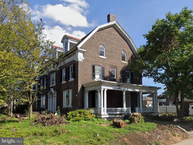 228 Cumberland St, Lebanon, PA 17042 - view of front facade featuring a porch, brick siding, and a chimney