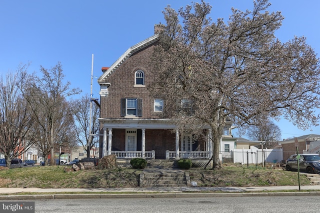 228 Cumberland St, Lebanon, PA 17042 - view of front of property with brick siding, covered porch, a chimney, and fence