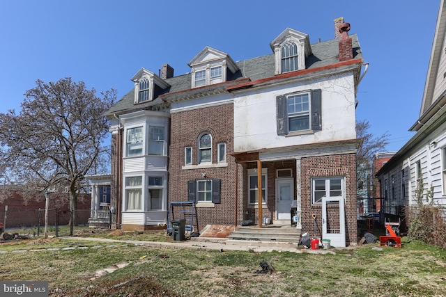 228 Cumberland St, Lebanon, PA 17042 - view of front of house featuring brick siding, a chimney, a front lawn, and fence