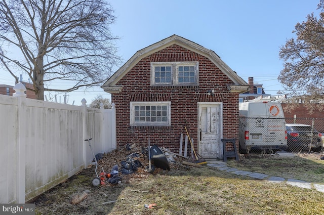 228 Cumberland St, Lebanon, PA 17042 - rear view of house with brick siding, a gambrel roof, and fence