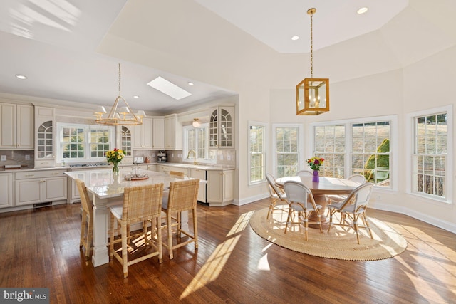 dining area featuring a tray ceiling, dark wood-type flooring, a wealth of natural light, and a chandelier