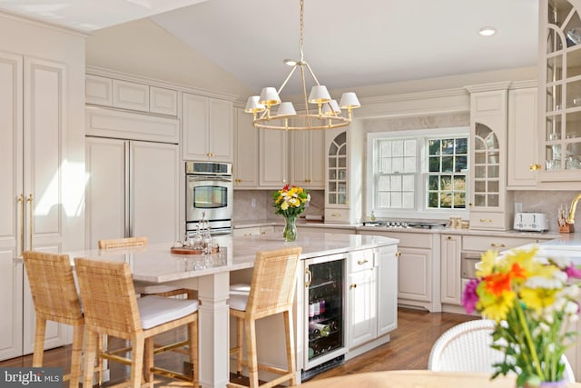 kitchen featuring beverage cooler, tasteful backsplash, stainless steel double oven, an inviting chandelier, and glass insert cabinets