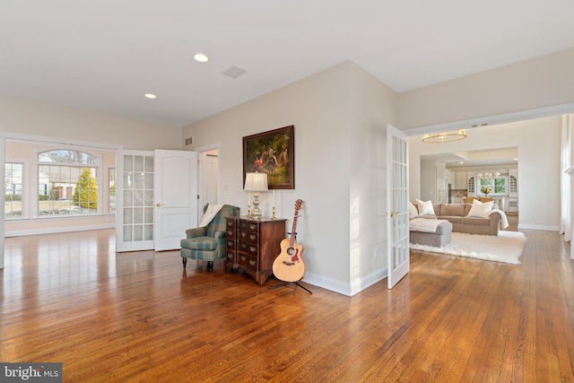 sitting room with wood finished floors, plenty of natural light, and french doors