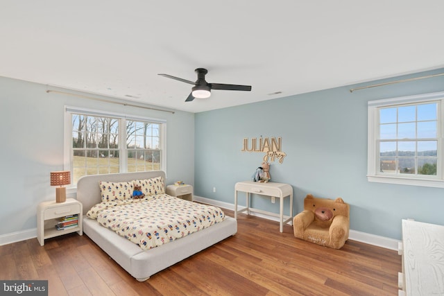 bedroom with wood finished floors, baseboards, and ceiling fan