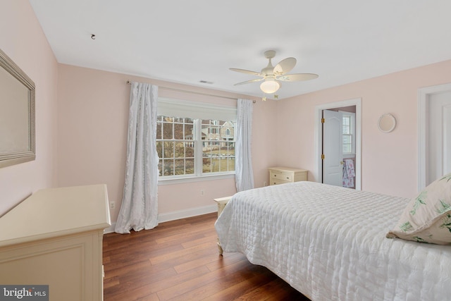 bedroom featuring visible vents, baseboards, wood finished floors, and a ceiling fan