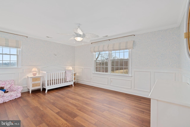 unfurnished bedroom with wallpapered walls and wainscoting