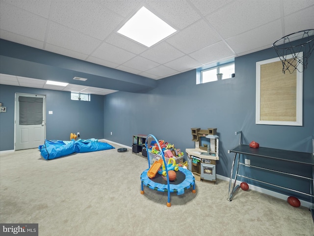 recreation room featuring a drop ceiling, baseboards, and carpet