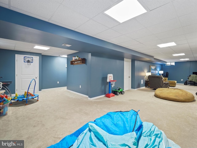 game room featuring a drop ceiling, baseboards, and carpet