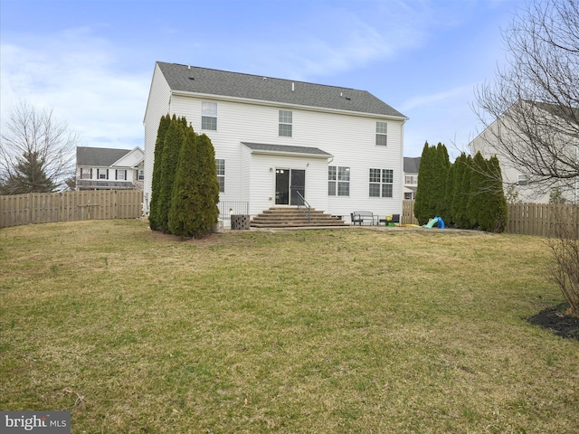 rear view of house with a lawn and fence