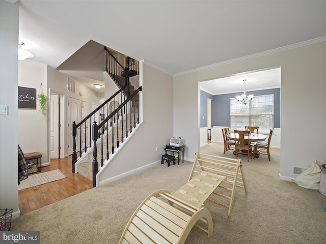 sitting room with stairs, carpet flooring, visible vents, and a chandelier