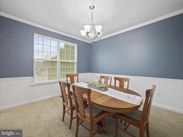 dining area featuring crown molding, a notable chandelier, and carpet floors