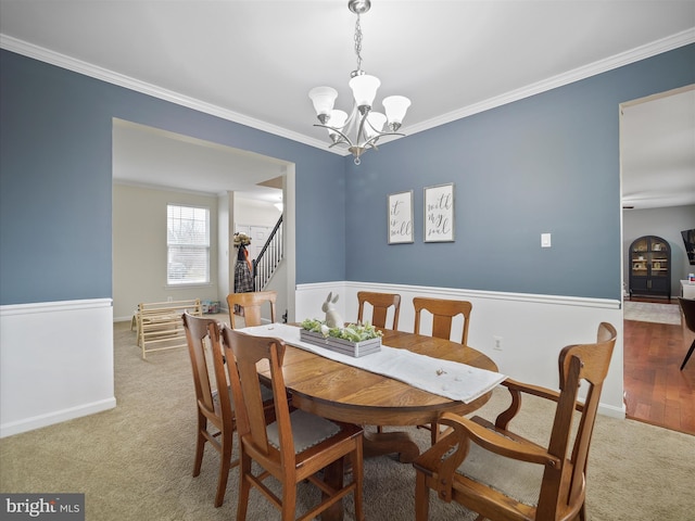 carpeted dining area featuring baseboards, stairs, an inviting chandelier, and ornamental molding