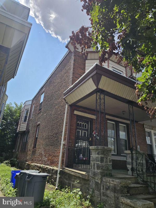 view of front facade featuring brick siding and a porch