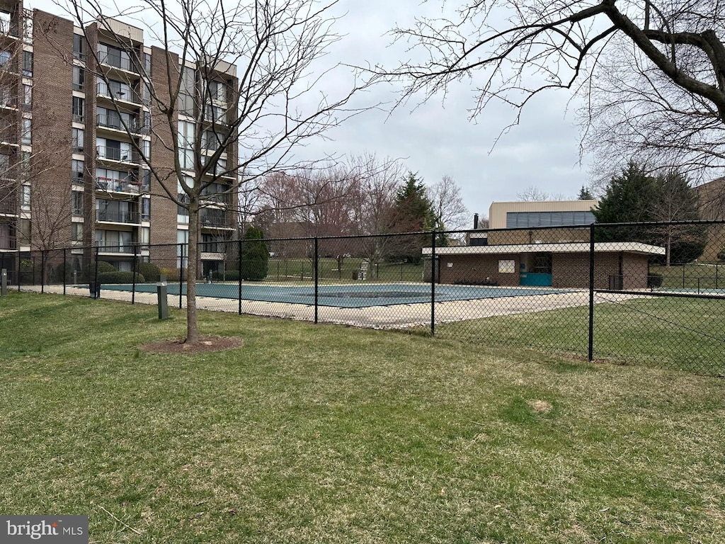 view of pool with a yard, a tennis court, and fence