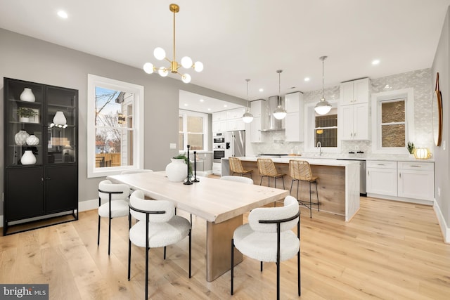 dining room featuring light wood finished floors, a chandelier, and recessed lighting