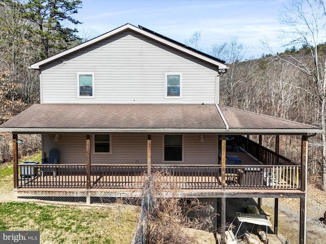 rear view of property with roof with shingles and a wooden deck