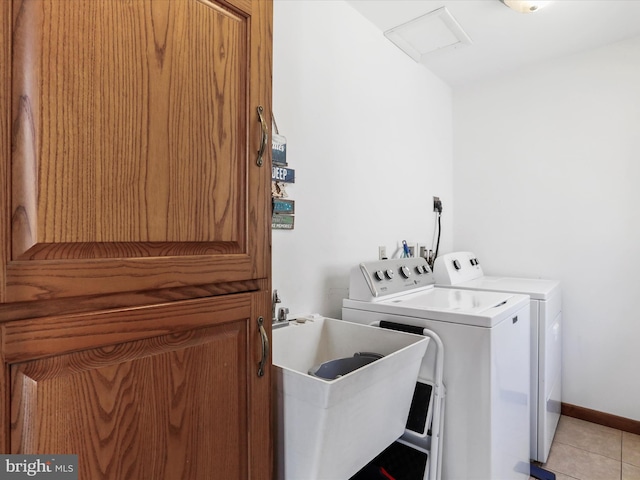 laundry area with washing machine and clothes dryer, attic access, light tile patterned floors, laundry area, and a sink