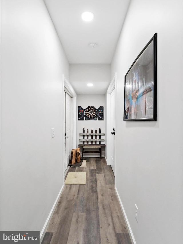 corridor featuring baseboards and wood finished floors