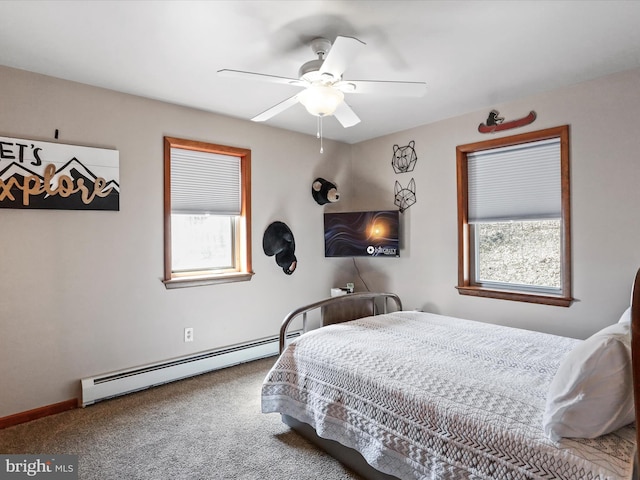 carpeted bedroom with ceiling fan, multiple windows, and a baseboard radiator