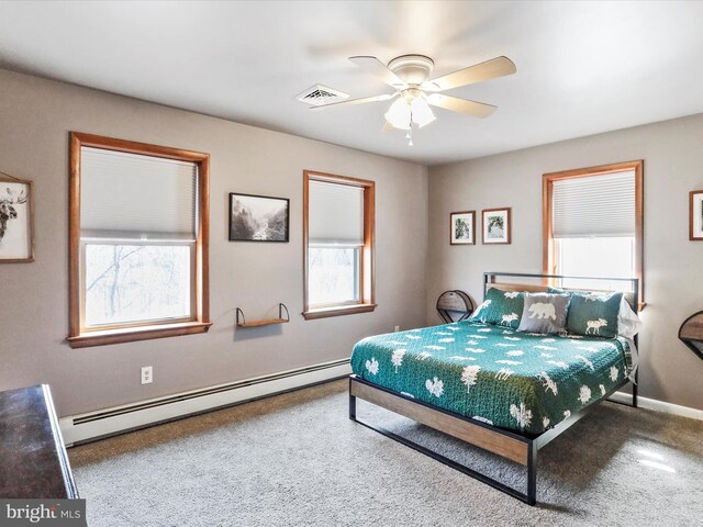 bedroom featuring visible vents, a ceiling fan, a baseboard heating unit, and baseboards