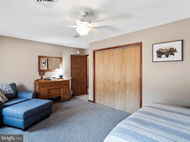 carpeted bedroom with a closet, visible vents, and a ceiling fan