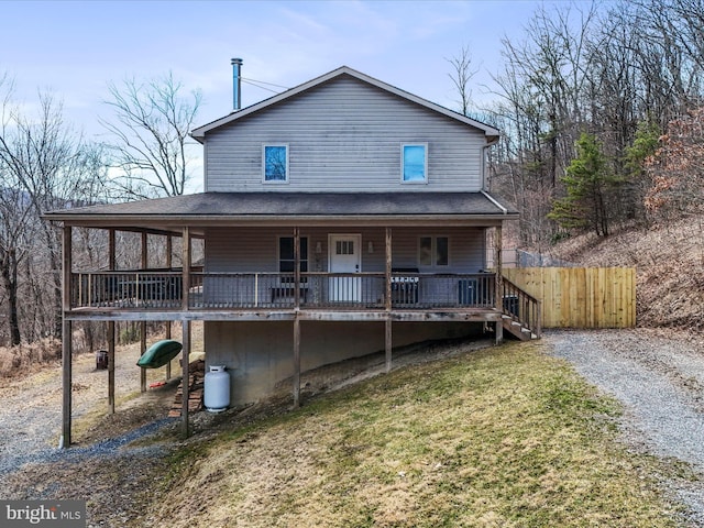 back of house with a lawn and fence