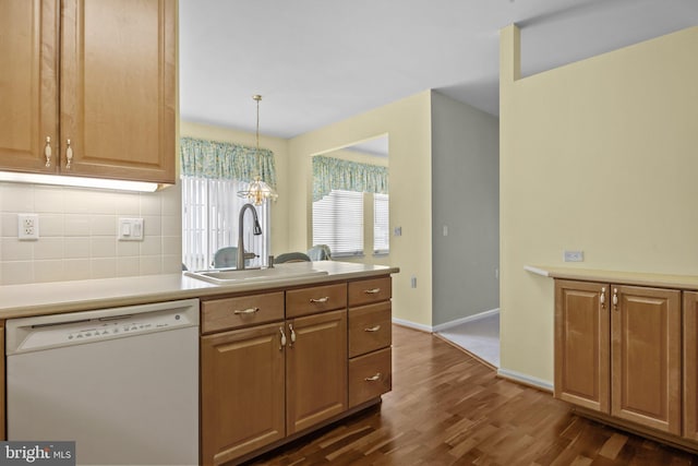 kitchen featuring tasteful backsplash, a sink, a chandelier, white dishwasher, and dark wood-style flooring