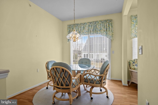 dining area featuring a notable chandelier, wood finished floors, and baseboards