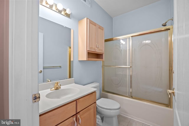 bathroom featuring visible vents, toilet, tile patterned floors, combined bath / shower with glass door, and vanity