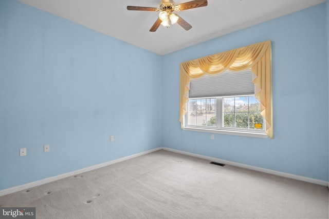 carpeted empty room featuring baseboards, visible vents, and ceiling fan