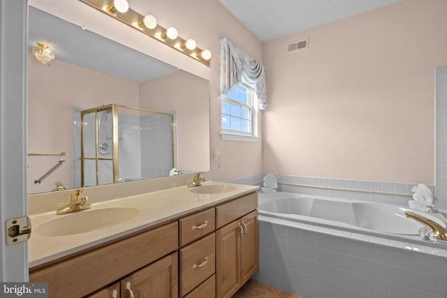 bathroom featuring double vanity, visible vents, a shower stall, and a sink