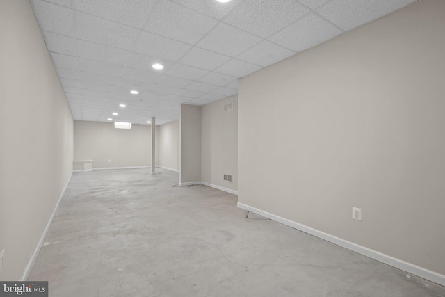 finished below grade area with a drop ceiling, baseboards, and visible vents