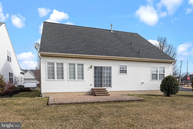 back of property with entry steps, a yard, a patio area, and a shingled roof