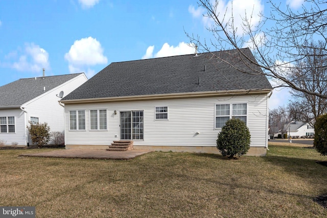 back of house with entry steps, a patio, a yard, and roof with shingles