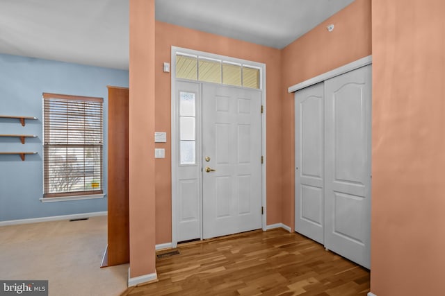 foyer with visible vents, baseboards, and wood finished floors