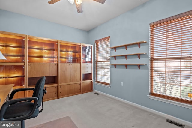 unfurnished office featuring visible vents, baseboards, carpet, and ceiling fan