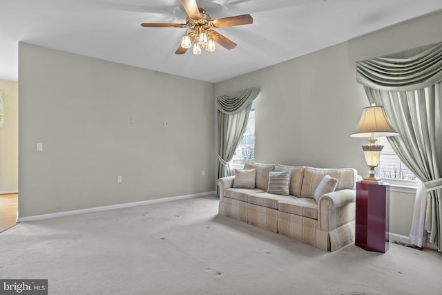 living room with ceiling fan, baseboards, and carpet