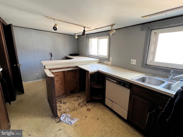 kitchen featuring light countertops, rail lighting, white dishwasher, and a sink