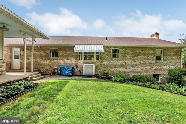 381 N Main St, Spring Grove, PA 17362 - rear view of house with central AC unit, brick siding, roof with shingles, and a yard