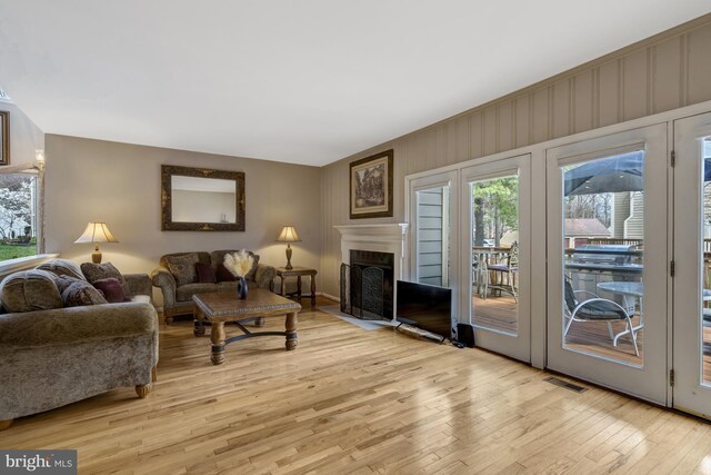 12521 N Lake Ct, Fairfax, VA 22033 - living room with light wood-style flooring, a healthy amount of sunlight, a fireplace with flush hearth, and visible vents