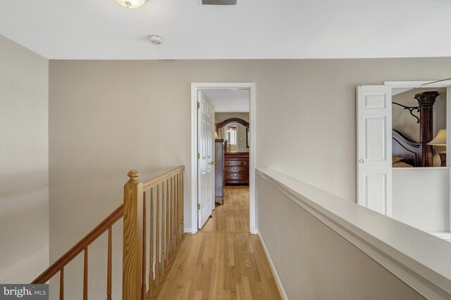 12521 N Lake Ct, Fairfax, VA 22033 - hallway with visible vents, light wood-style flooring, an upstairs landing, and baseboards