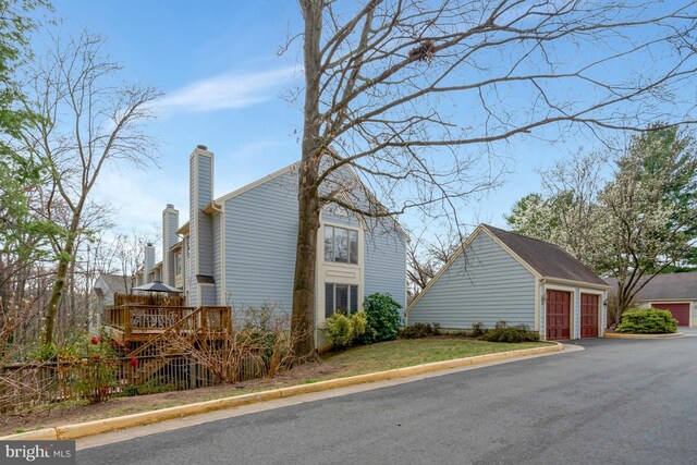 12521 N Lake Ct, Fairfax, VA 22033 - view of side of property with a chimney, a garage, a wooden deck, and an outbuilding