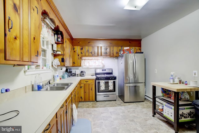 kitchen with a sink, light countertops, brown cabinets, appliances with stainless steel finishes, and open shelves