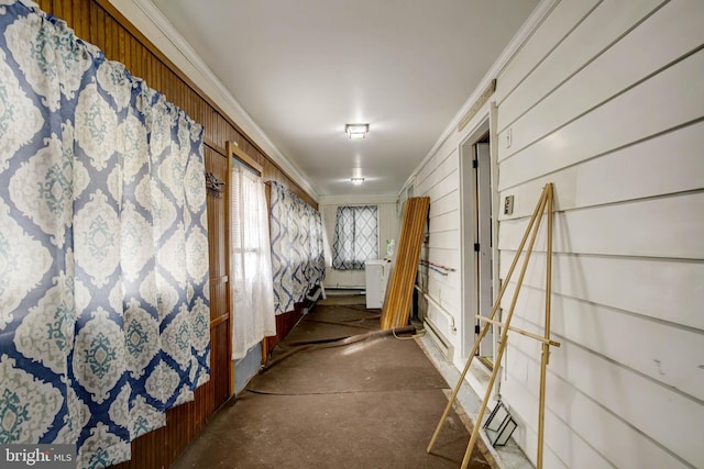 hall with concrete flooring and ornamental molding